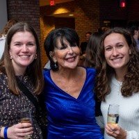 Girl in white shirt and patterned shirt take a picture with President Mantella